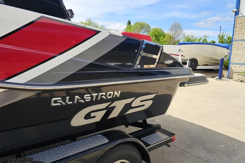 Slide: The Image of 2020 Glastron GTS 225 boat with sleek design and vibrant colors on a trailer. - 28