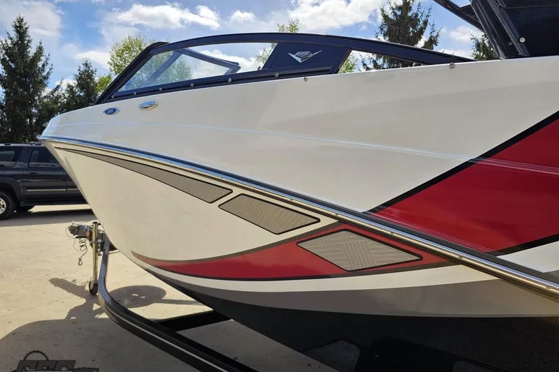 Slide: The Image of 2020 Glastron GTS 225 boat with sleek red and white design on a trailer. - 29