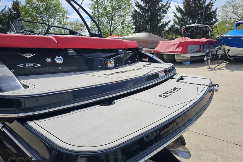 Slide: The Image of 2020 Glastron GTS 225 boat with red seating and sleek design, parked outdoors. - 33