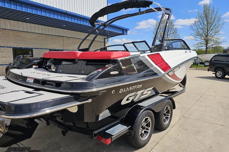 Slide: The Image of 2020 Glastron GTS 225 boat on trailer, parked outdoors under blue sky. - 37