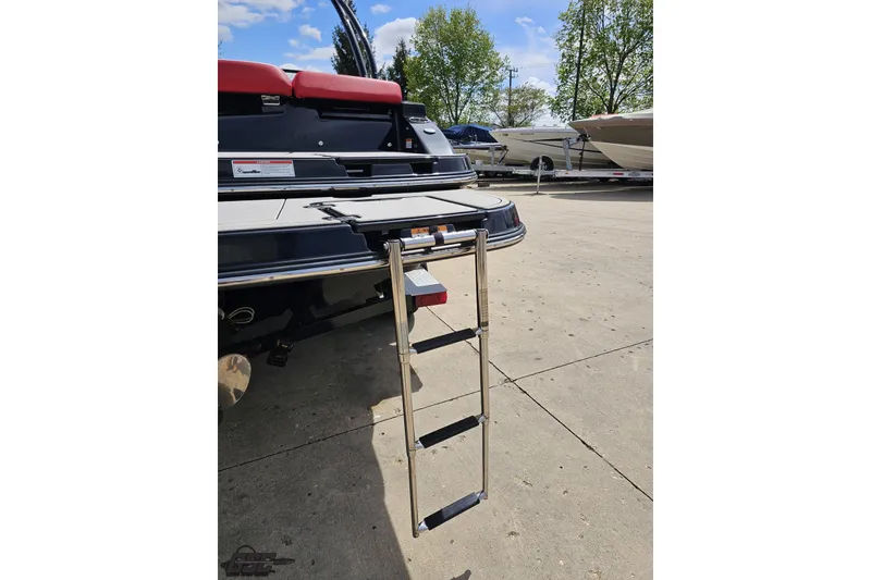 Slide: The Image of 2020 Glastron GTS 225 boat with extended swim ladder on concrete surface. - 38