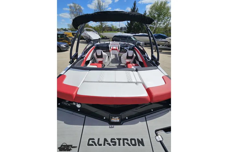 Slide: The Image of 2020 Glastron GTS 225 boat with red and white seating, docked outdoors. - 42