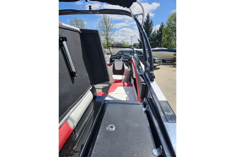 Slide: The Image of 2020 Glastron GTS 225 boat interior with red and white seating, open storage compartment. - 47
