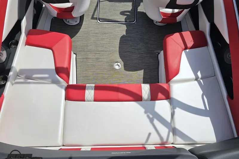 Slide: The Image of 2020 Glastron GTS 225 boat interior with red and white seating, gray flooring. - 48