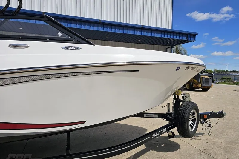 Slide: The Image of 2020 Glastron GTS 225 boat on trailer, parked outdoors under blue sky. - 5