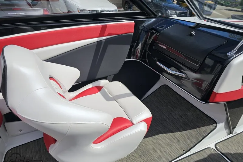 Slide: The Image of 2020 Glastron GTS 225 boat interior with red and white seating, sleek dashboard design. - 56