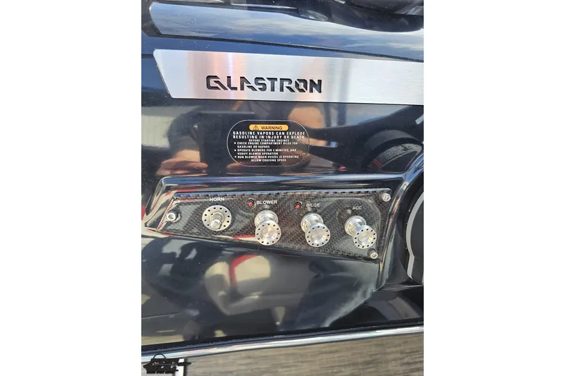 Slide: The Image of Control panel of 2020 Glastron GTS 225 boat with switches and warning label. - 69