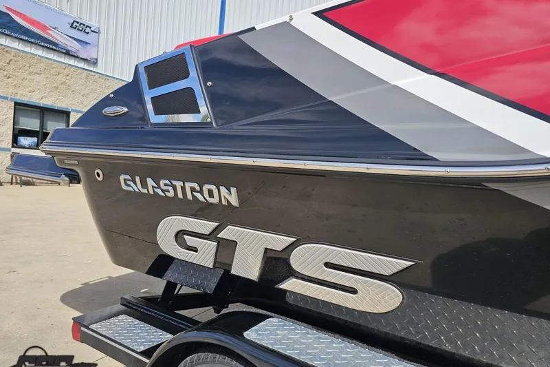 Slide: The Image of 2020 Glastron GTS 225 boat with sleek design and bold graphics on trailer. - 7