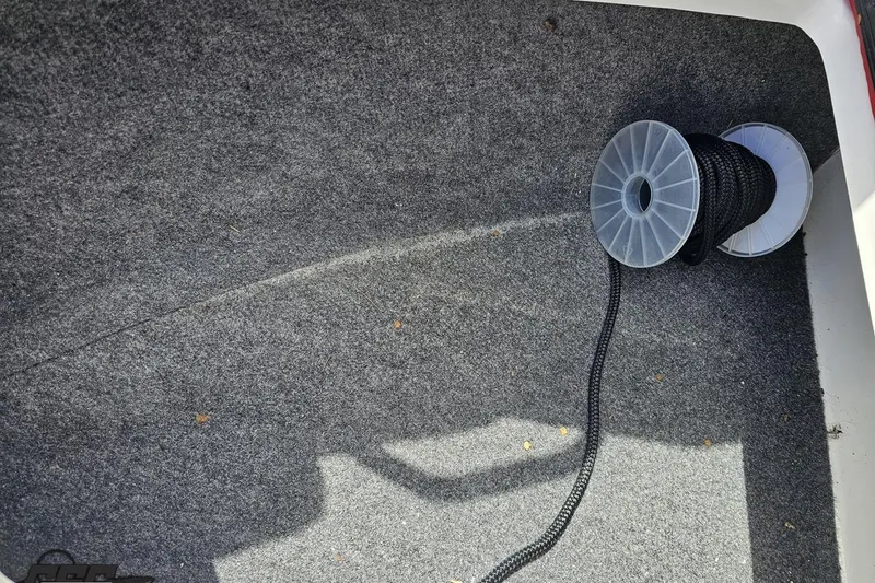 Slide: The Image of Carpeted interior of a 2020 Glastron GTS 225 boat with a spool of black rope. - 78