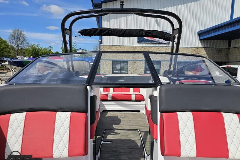 Slide: The Image of 2020 Glastron GTS 225 boat interior with red and white seating, docked outdoors. - 87