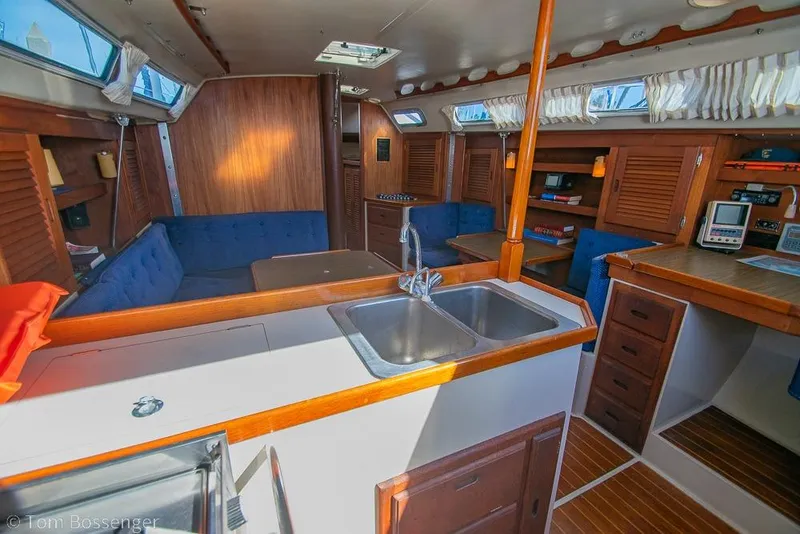 Slide: The Image of Interior of a 1987 Catalina 36 sailboat with wood finishes and blue seating. - 10