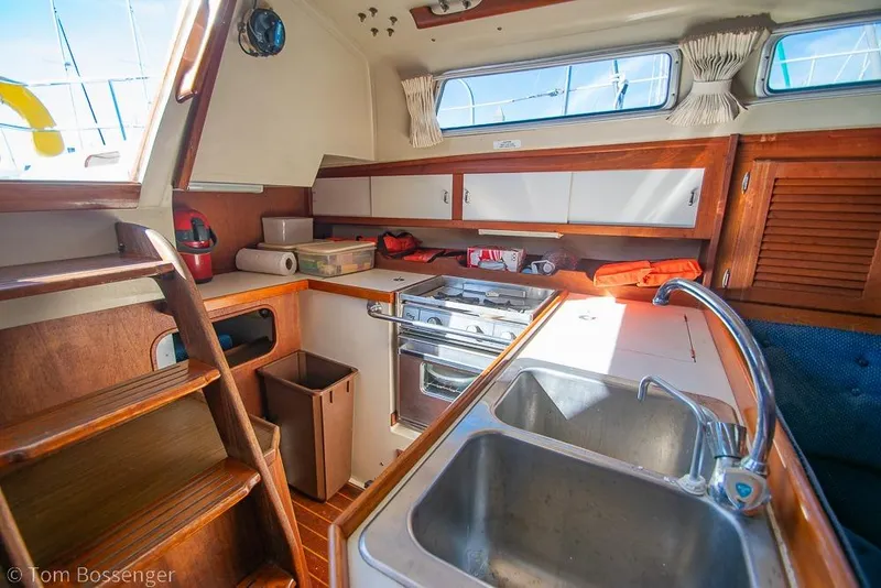 Slide: The Image of Interior of a 1987 Catalina 36 sailboat kitchen with wooden cabinetry and stainless steel sink. - 11