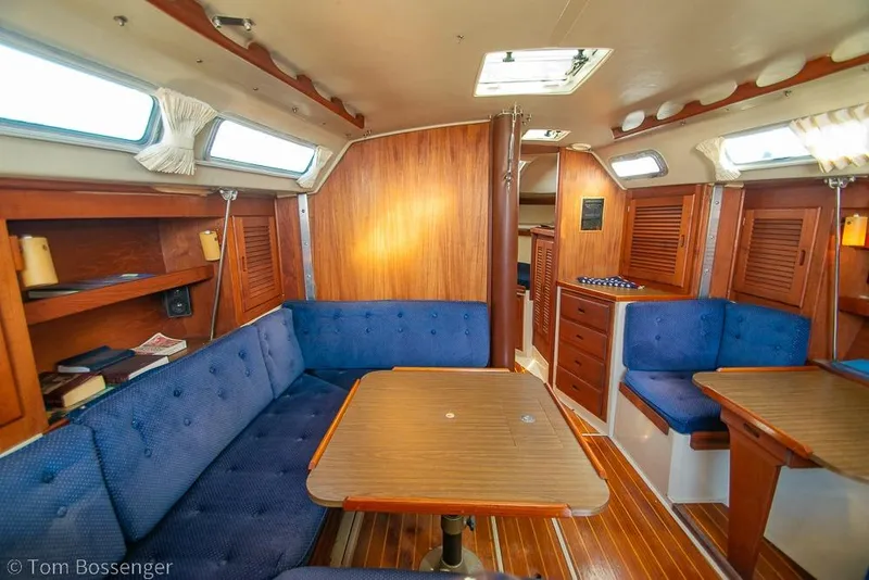 Slide: The Image of Interior of a 1987 Catalina 36 sailboat with wooden furnishings and blue seating. - 13
