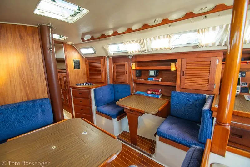 Slide: The Image of Interior of a 1987 Catalina 36 sailboat with wooden furnishings and blue seating. - 14