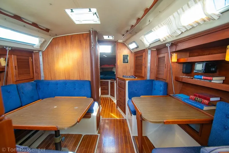 Slide: The Image of Interior of a 1987 Catalina 36 sailboat with wooden furnishings and blue seating. - 15