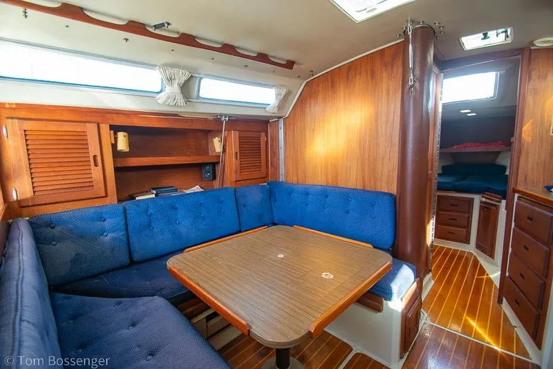 Slide: The Image of Interior of a 1987 Catalina 36 sailboat with blue seating and wooden finishes. - 16
