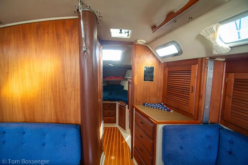 Slide: The Image of Interior of a 1987 Catalina 36 sailboat with wooden cabinetry and blue seating. - 18