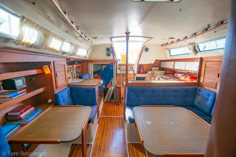 Slide: The Image of Interior of a 1987 Catalina 36 sailboat with wooden furnishings and blue seating. - 21