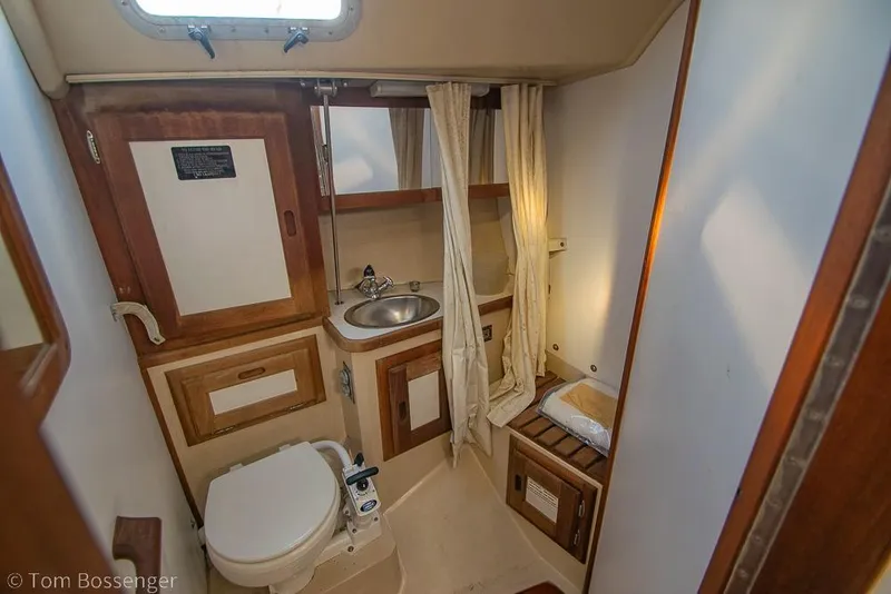 Slide: The Image of Bathroom interior of a 1987 Catalina 36 sailboat, featuring sink and toilet. - 22