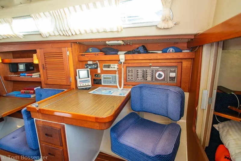Slide: The Image of Interior of 1987 Catalina 36 sailboat with navigation station and blue cushioned seating. - 23