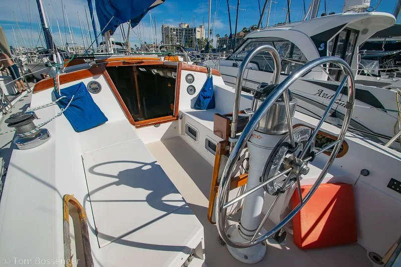 Slide: The Image of Cockpit of a 1987 Catalina 36 sailboat with steering wheel and marina view. - 27
