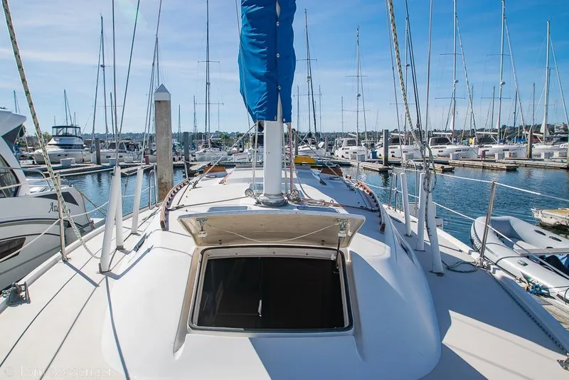 Slide: The Image of 1987 Catalina 36 sailboat docked in a marina, surrounded by other boats. - 38