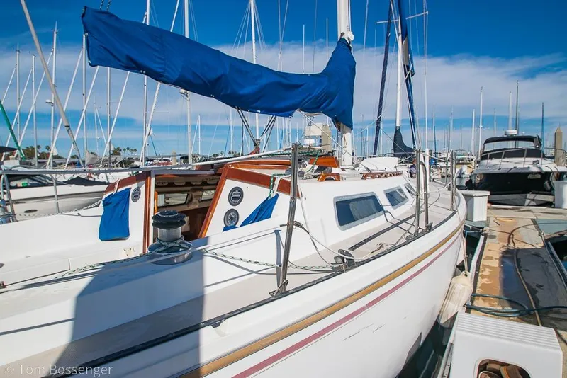 Slide: The Image of 1987 Catalina 36 sailboat docked at marina, featuring blue sail cover and white deck. - 5