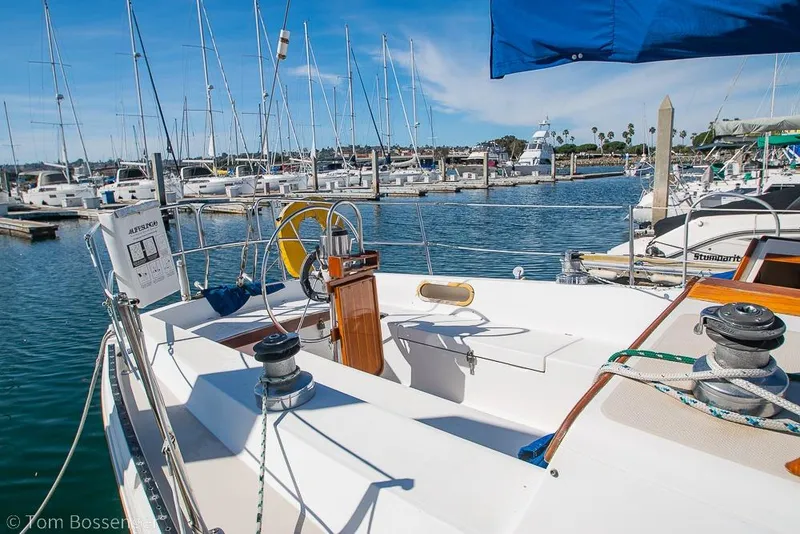 Slide: The Image of 1987 Catalina 36 sailboat docked in a marina, featuring a spacious cockpit and steering wheel. - 6