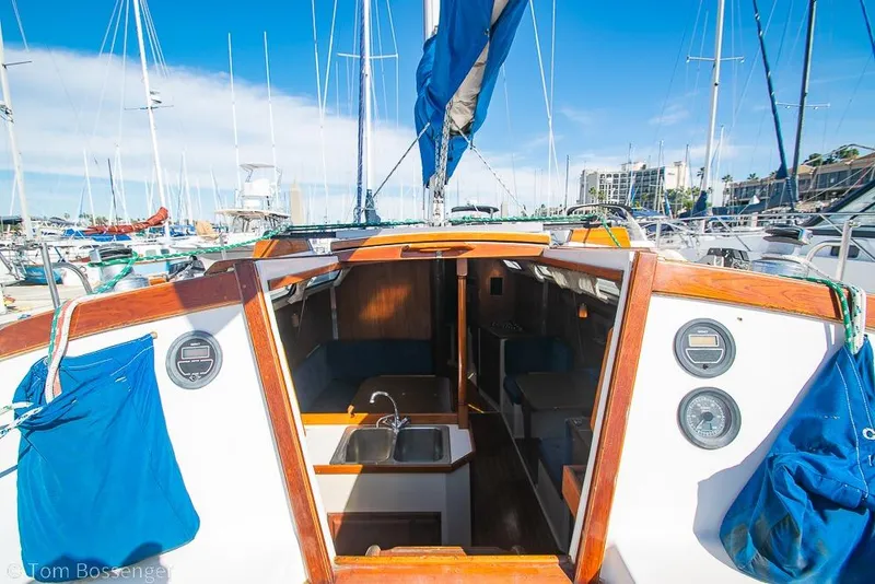 Slide: The Image of 1987 Catalina 36 sailboat interior view at marina, showcasing cabin and sink area. - 7