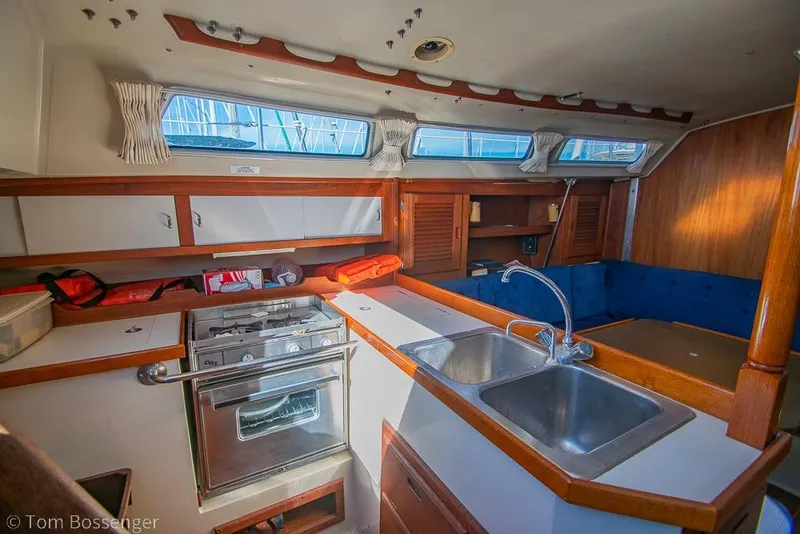 Slide: The Image of Interior of a 1987 Catalina 36 sailboat featuring a compact kitchen and seating area. - 9