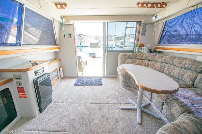 Slide: The Image of Interior of a 1991 Sea Ray 370 Sedan Bridge yacht with seating and table. - 12