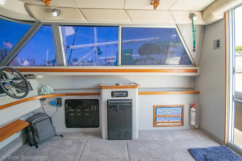 Slide: The Image of Interior of 1991 Sea Ray 370 Sedan Bridge with helm, windows, and seating area. - 13