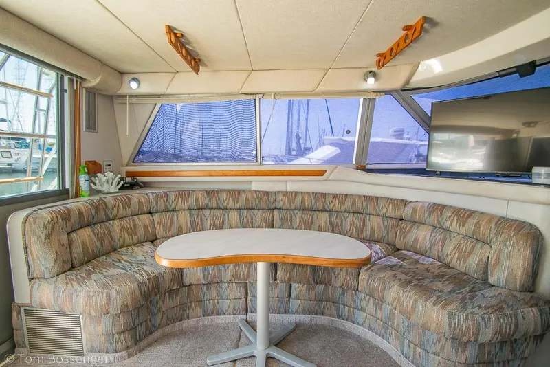 Slide: The Image of Interior of 1991 Sea Ray 370 Sedan Bridge with curved seating and table. - 14