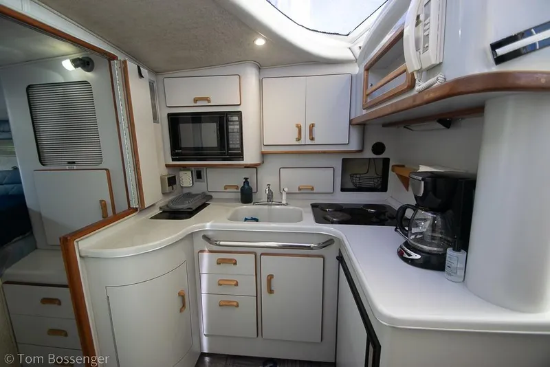 Slide: The Image of 1991 Sea Ray 370 Sedan Bridge kitchen with microwave, sink, and coffee maker. - 18