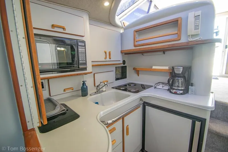 Slide: The Image of 1991 Sea Ray 370 Sedan Bridge kitchen with microwave, sink, stove, and coffee maker. - 19