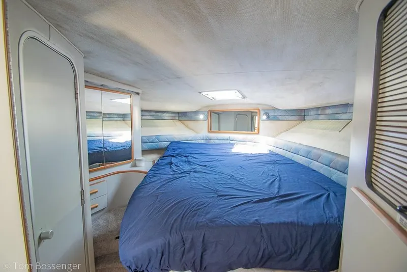 Slide: The Image of Interior cabin of 1991 Sea Ray 370 Sedan Bridge with blue bedding and mirrored closet. - 20