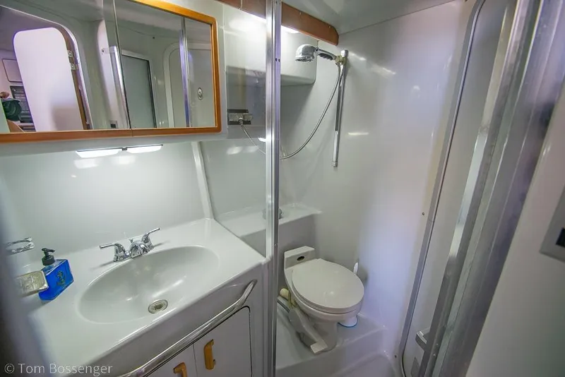 Slide: The Image of Bathroom interior of 1991 Sea Ray 370 Sedan Bridge yacht, featuring sink and toilet. - 23