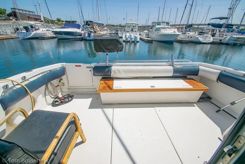 Slide: The Image of 1991 Sea Ray 370 Sedan Bridge yacht interior at marina, showcasing seating and docked boats. - 24