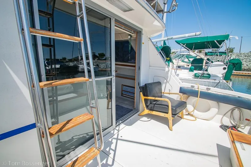 Slide: The Image of 1991 Sea Ray 370 Sedan Bridge yacht deck with ladder and chair in marina. - 25