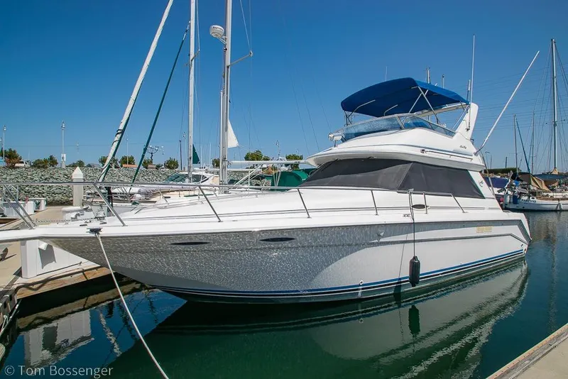 Slide: The Image of 1991 Sea Ray 370 Sedan Bridge yacht docked in a marina under clear blue skies. - 3