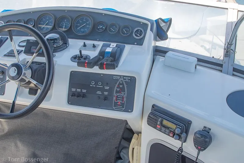 Slide: The Image of 1991 Sea Ray 370 Sedan Bridge helm with steering wheel, gauges, and controls. - 30