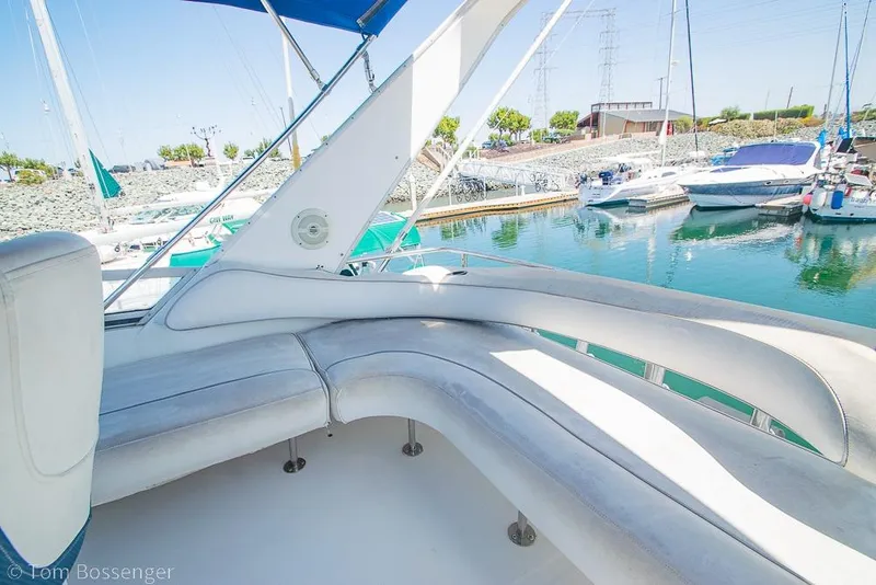Slide: The Image of 1991 Sea Ray 370 Sedan Bridge yacht interior with marina view, featuring comfortable seating. - 32