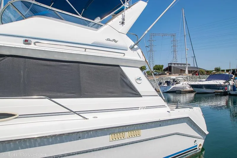 Slide: The Image of 1991 Sea Ray 370 Sedan Bridge yacht docked in a marina under clear blue skies. - 4
