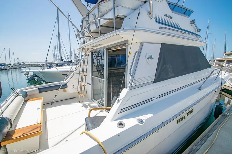 Slide: The Image of 1991 Sea Ray 370 Sedan Bridge yacht docked at a marina under clear blue skies. - 6