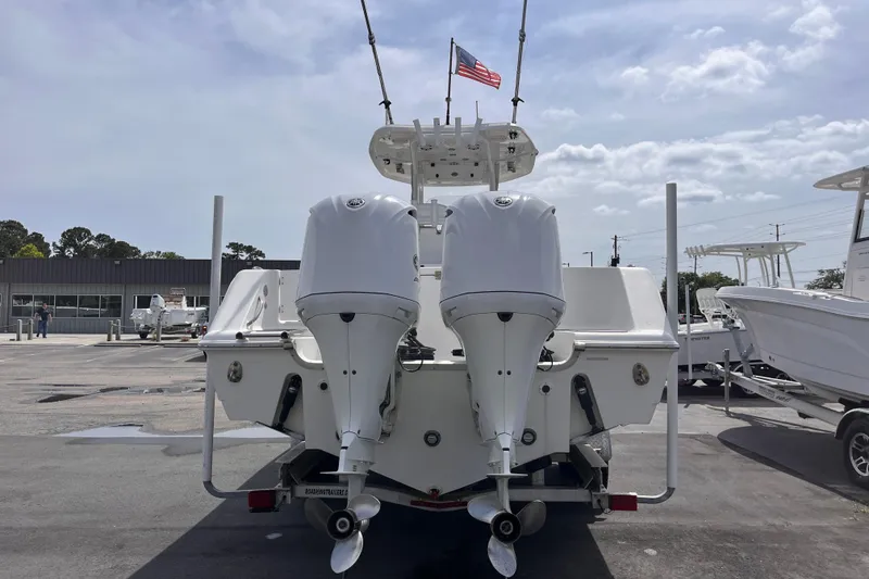 Slide: The Image of 2019 Tidewater 280 CC Adventure boat with dual outboard motors, docked under a cloudy sky. - 3