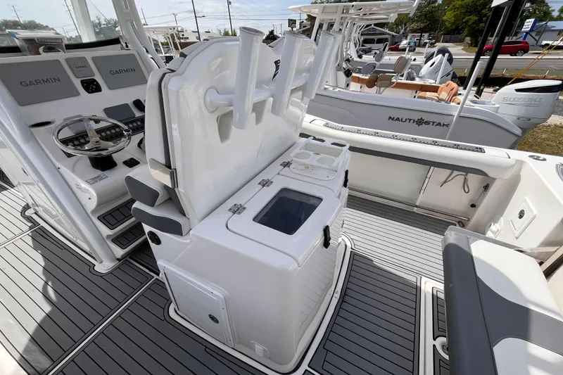 Slide: The Image of 2019 Tidewater 280 CC Adventure boat interior with Garmin controls and fishing rod holders. - 7