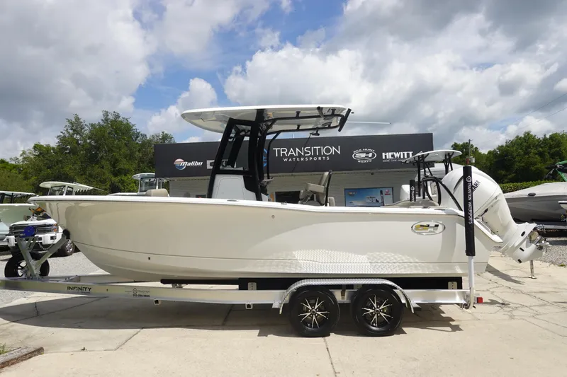 The Image of 2026 Sea Hunt Ultra 245 SE boat on trailer at dealership, under cloudy sky. - 1