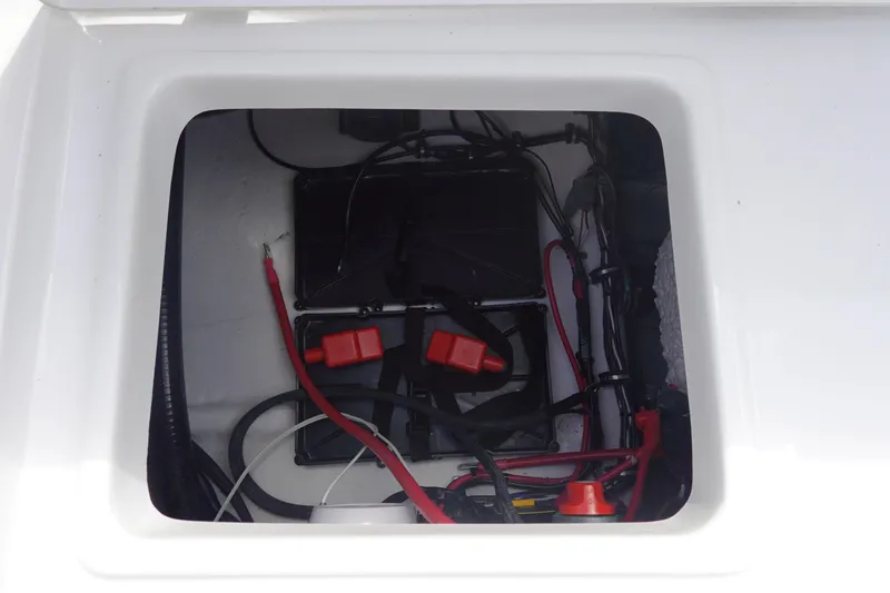 Slide: The Image of Battery compartment of 2026 Sea Hunt Ultra 245 SE boat with wiring and connectors. - 15