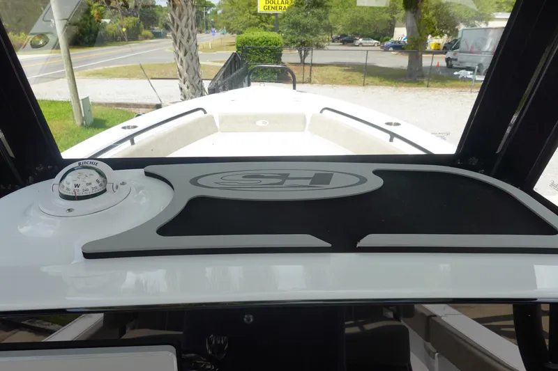 Slide: The Image of 2026 Sea Hunt Ultra 245 SE boat dashboard with compass and logo. - 24