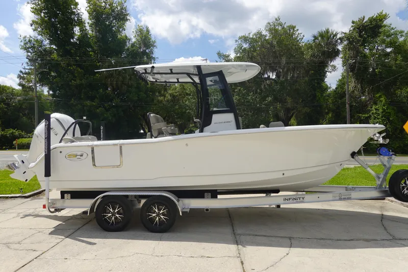 Slide: The Image of 2026 Sea Hunt Ultra 245 SE boat on trailer, parked outdoors under a cloudy sky. - 4